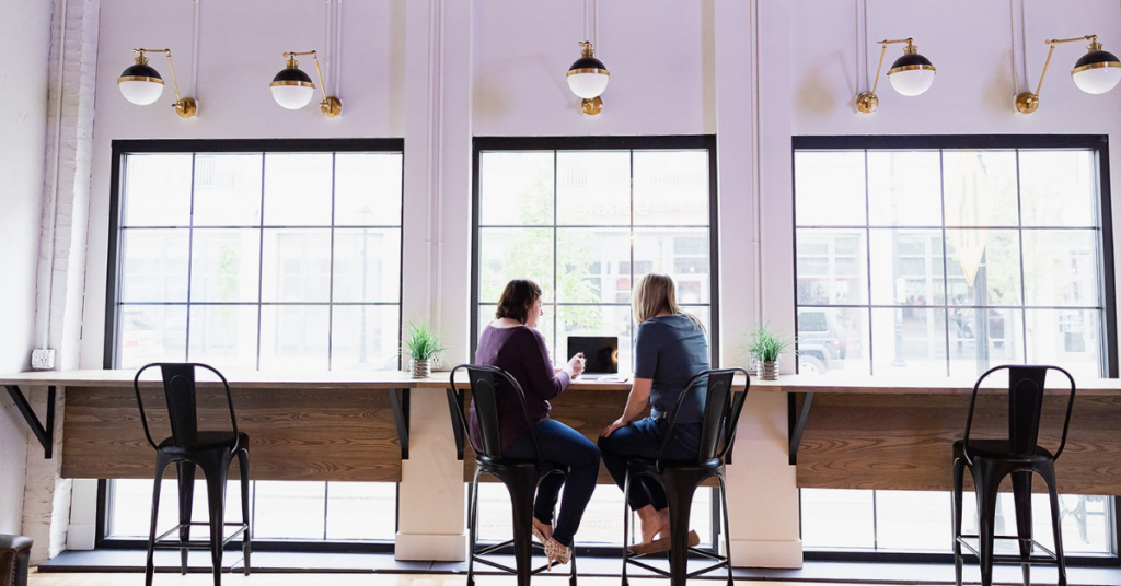 two females working out of brick and mortar office using our shared coworking space.