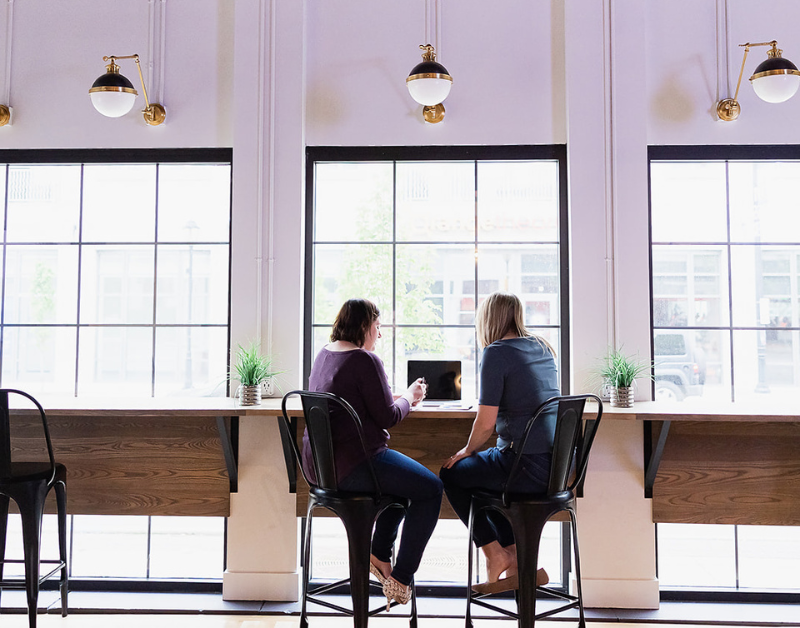 two females working out of brick and mortar office using our shared coworking space.