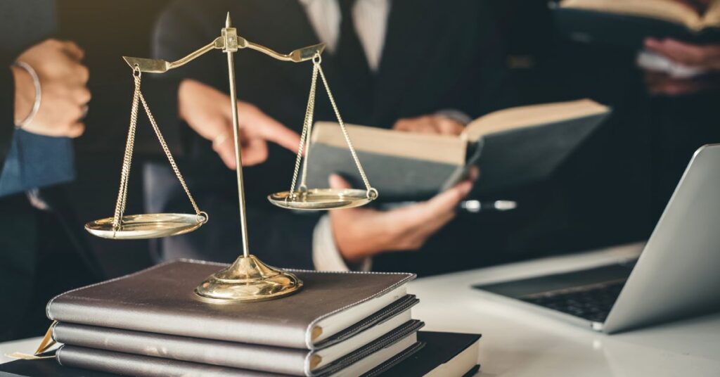 close up of a private office space for a lawyer desk showing his laptop and pile of books