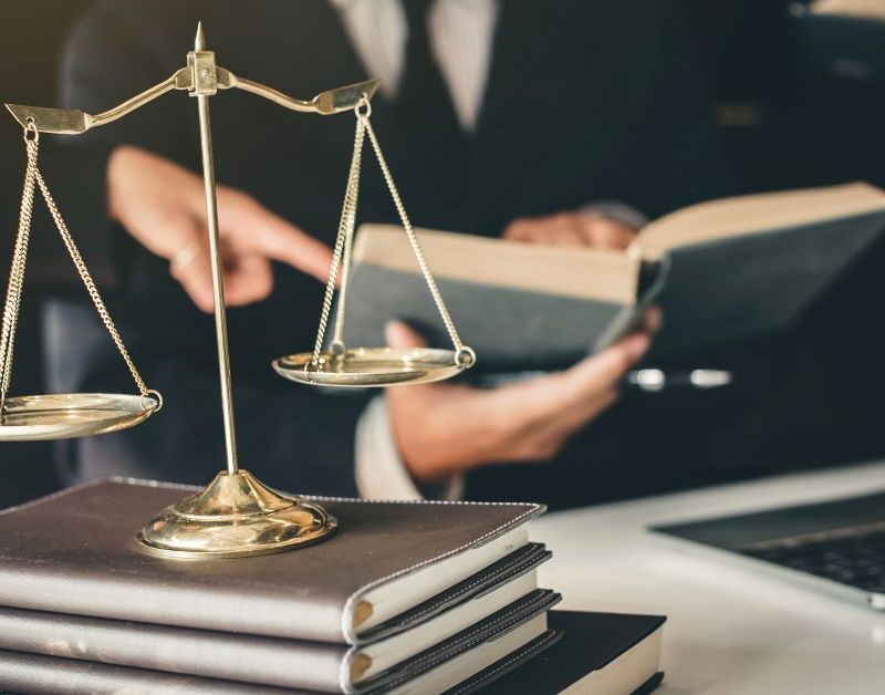 close up of a private office space for a lawyer desk showing his laptop and pile of books