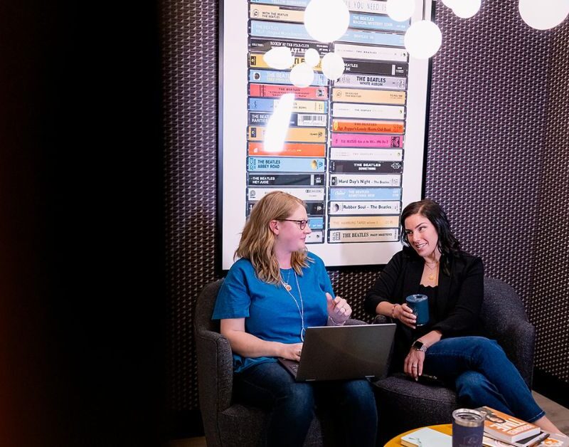 Two women having a professional meeting inside a Brick & Mortar workspace.