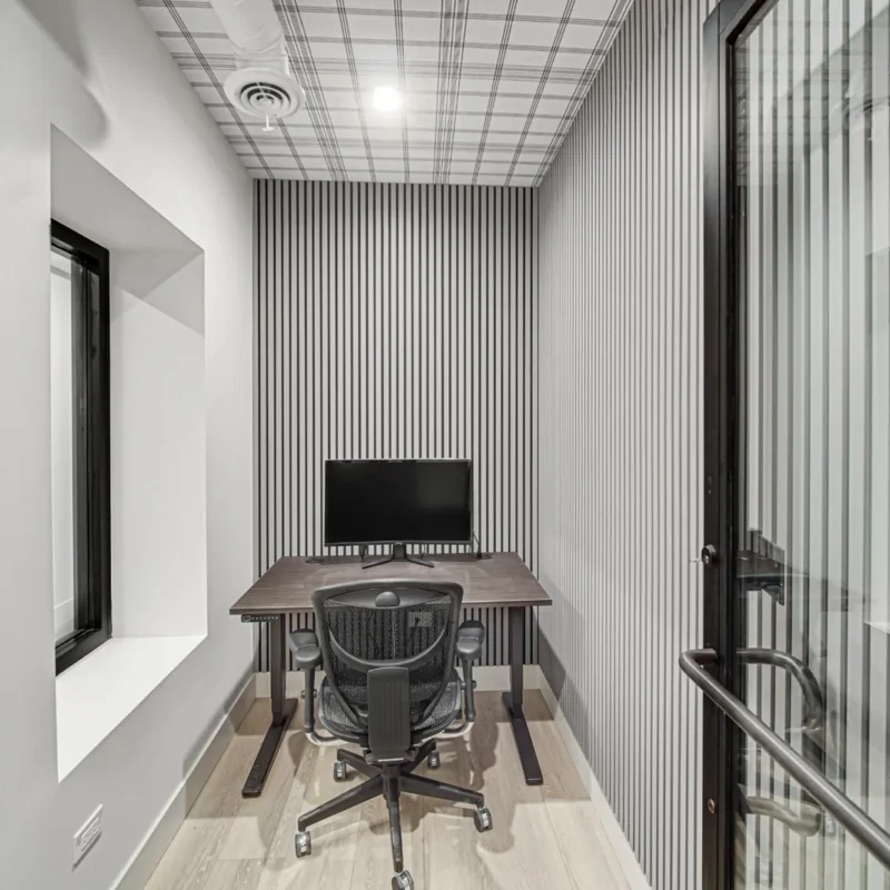 Furnished private office with desk, monitor, and ergonomic chair at Brick & Mortar